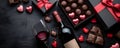 Bottle of red wine with box of chocolate candies on dark grey background Royalty Free Stock Photo