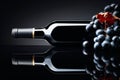 Bottle of red wine and a bunch of grapes on a black reflective background Royalty Free Stock Photo