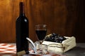 Bottle of red wine in wine cellar for tasting. Red wooden background with wooden box with grapes. Wine tradition and culture conce Royalty Free Stock Photo