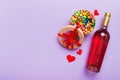 Bottle of red wine on colored background for Valentine Day with gift and chocolate. Heart shaped with gift box of Royalty Free Stock Photo