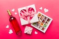 Bottle of red wine on colored background for Valentine Day with gift and chocolate. Heart shaped with gift box of Royalty Free Stock Photo