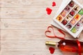 Bottle of red wine on colored background for Valentine Day with gift and chocolate. Heart shaped with gift box of Royalty Free Stock Photo