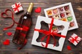 Bottle of red wine on colored background for Valentine Day with gift and chocolate. Heart shaped with gift box of Royalty Free Stock Photo