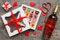 Bottle of red wine on colored background for Valentine Day with gift and chocolate. Heart shaped with gift box of Royalty Free Stock Photo