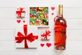 Bottle of red wine on colored background for Valentine Day with gift and chocolate. Heart shaped with gift box of Royalty Free Stock Photo