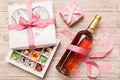 Bottle of red wine on colored background for Valentine Day with gift and chocolate. Heart shaped with gift box of Royalty Free Stock Photo