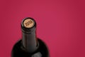 Bottle of red wine with cork on purple background