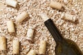 Bottle of red wine with corks on old wooden table with scattered sawdust Royalty Free Stock Photo