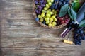 Bottle with red wine, corkscrew, blue grapes in basket, leaves on a wooden table. Wine background with copy space. Top view, flat Royalty Free Stock Photo