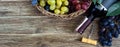 Bottle with red wine, corkscrew, blue grapes in basket, leaves on a wooden table. Wine background with copy space. Top view, flat Royalty Free Stock Photo