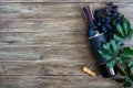 Bottle with red wine, corkscrew, blue grapes, leaves on a wooden table. Wine background with copy space. Top view, flat lay Royalty Free Stock Photo