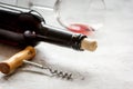 Bottle of red wine with corkscrew on white stone background Royalty Free Stock Photo