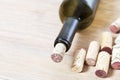 A bottle of red wine covered with a cork on a blurred wooden background with copy space. Close up bottleneck of wine