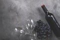 1 bottle of red wine, dark grapes, 1 glass on a gray background copy space