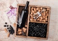 Bottle of red wine and empty glass with dark grapes with corks and opener inside vintage wooden box on wooden background with Royalty Free Stock Photo