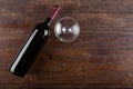 Bottle with red wine and an empty glass, on a wooden background. View from above Royalty Free Stock Photo