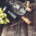 Bottle of red wine with fresh grape and bunch of corks on wooden table Royalty Free Stock Photo