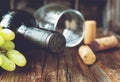 Bottle of red wine with fresh grape and bunch of corks on wooden table Royalty Free Stock Photo