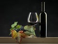 Bottle red wine, glass, grapes black background Royalty Free Stock Photo