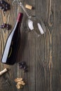 A bottle with red wine, a wine glass and grapes on an old wooden table Royalty Free Stock Photo