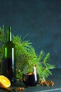 A bottle of red wine a glass of mulled wine on a background of pine branches