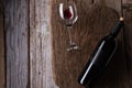 Bottle of red wine and glass with remains wine lies on wooden board o rustic background. Flat lay. Space for text. Delicious Royalty Free Stock Photo