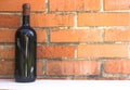 Bottle of red wine near wall of orange bricks. loft style Royalty Free Stock Photo