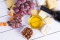 Bottle of red wine with snacks - various types of cheese, figs, nuts, honey, grapes on a wooden boards background Royalty Free Stock Photo