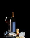 A bottle of red wine, two glasses with a drink, a bunch of grapes and cheese Royalty Free Stock Photo