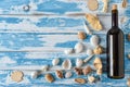 Bottle of red wine on vintage blue wooden board with seashells. Royalty Free Stock Photo