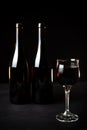 Bottle of red wine, bottle of white wine, and glass on a black background Royalty Free Stock Photo