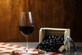 Bottle of red wine in wine cellar for tasting. Red wooden background with wooden box with grapes. Wine tradition and culture conce Royalty Free Stock Photo