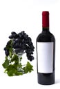 bottle with red wine, wine glass with grapes, on a white background , no people, vertical Royalty Free Stock Photo