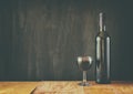 Bottle of red wine and wine glass over wooden table. image is filtered, instagram style