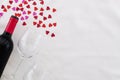 Bottle red wine and wine glasses on a white background decorated by red hearts. Top view with copy space for your text Royalty Free Stock Photo