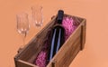 A bottle of red wine in a wooden box and two empty glasses Royalty Free Stock Photo