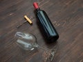 Bottle of red wine, a glass and a corkscrew on the table