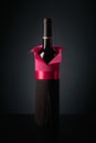 Bottle of red wine wrapped in crepe paper on a black background Royalty Free Stock Photo