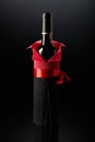 Bottle of red wine wrapped in crepe paper on a black background Royalty Free Stock Photo