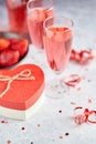 Bottle of rose champagne, glasses with fresh strawberries and heart shaped gift