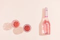 Bottle of rose champagne wine and two glasses with drink in bright sunlight. Summer vacation concept. Royalty Free Stock Photo