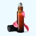 Bottle of rose essential oil and flower petals on white background Royalty Free Stock Photo