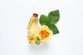 Bottle of rose essential oil and flowers on white background Royalty Free Stock Photo