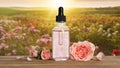 Bottle of rose essential oil and flowers on table against blurred background Royalty Free Stock Photo