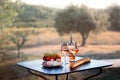 Bottle of rose wine and two full glasses of wine on table in heart of Provence, France with french bread, cheese, ham, grapes and Royalty Free Stock Photo