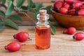 A bottle of rosehip seed oil with red rosehips