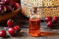 A bottle of rosehip seed oil with dried rosehips