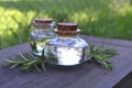 A bottle of rosemary aromatherapy oil, rosemary oil jar glass bottle and branches of rosemary