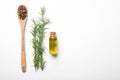 Bottle of rosemary oil, wooden spoon with spices and fresh twigs