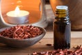 A bottle of sandalwood essential oil with sandalwood pieces